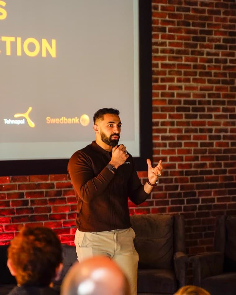 Mohammed Alsaadi speaking at an event, presenting to a seated audience